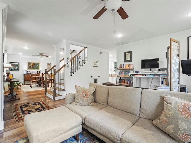 living room featuring hardwood / wood-style floors, ceiling fan, and ornamental molding