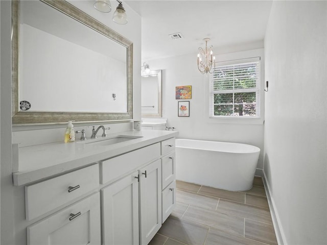 bathroom with a bathtub, vanity, and an inviting chandelier