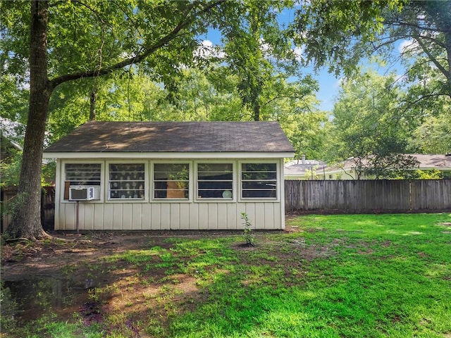 view of outdoor structure with cooling unit and a lawn