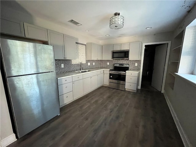 kitchen featuring white cabinetry, sink, dark hardwood / wood-style flooring, decorative backsplash, and appliances with stainless steel finishes