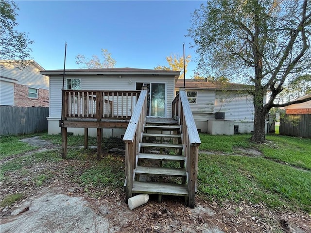 back of property featuring a lawn and a wooden deck