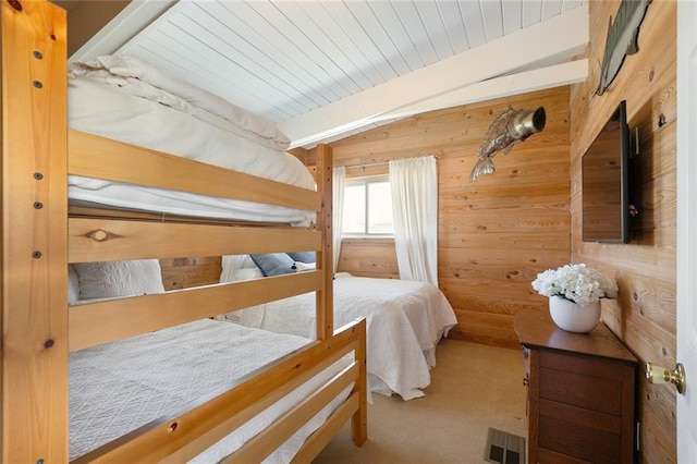 bedroom featuring beamed ceiling, carpet floors, wooden ceiling, and wooden walls