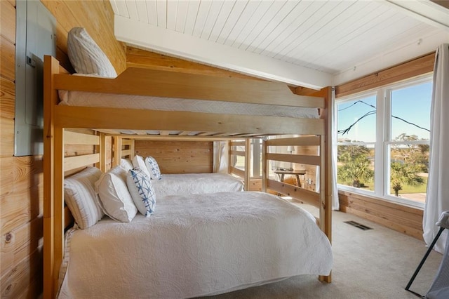 unfurnished bedroom with carpet, vaulted ceiling with beams, wooden ceiling, and wood walls