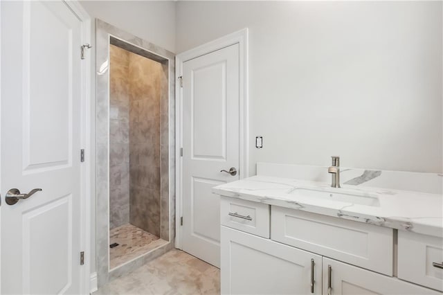 bathroom featuring a tile shower and vanity