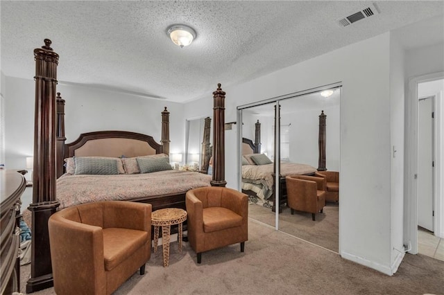 carpeted bedroom featuring a textured ceiling and a closet