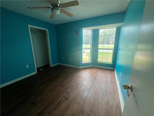 unfurnished bedroom with a textured ceiling, a closet, hardwood / wood-style flooring, and ceiling fan