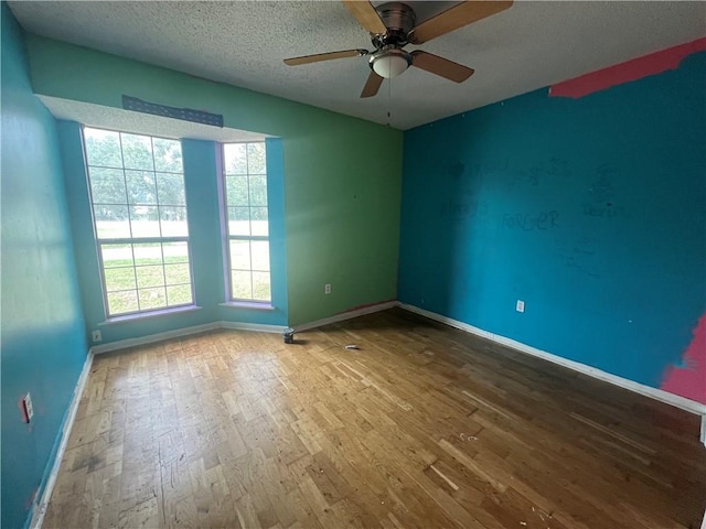 unfurnished room featuring a textured ceiling, hardwood / wood-style flooring, and ceiling fan