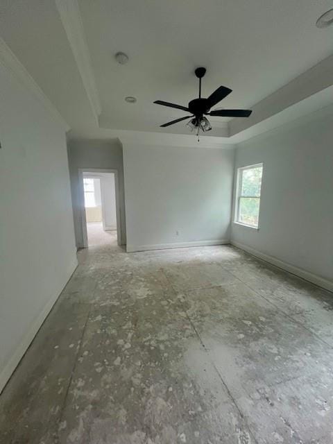 empty room with a raised ceiling and ceiling fan