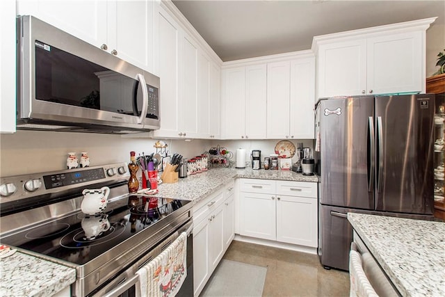 kitchen with light stone counters, white cabinetry, and appliances with stainless steel finishes