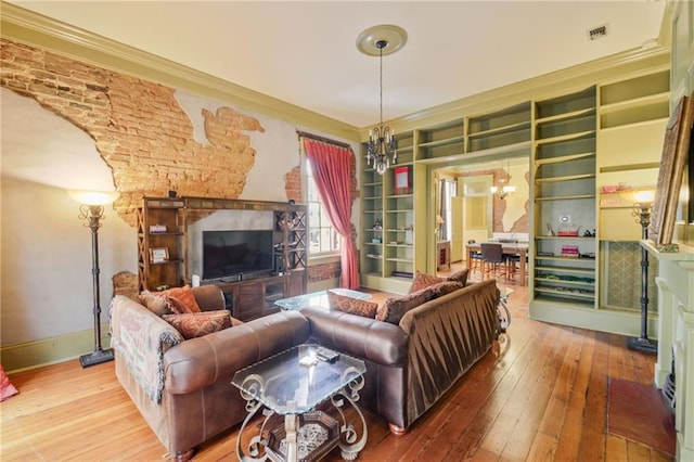 living room with hardwood / wood-style floors, a notable chandelier, crown molding, and brick wall