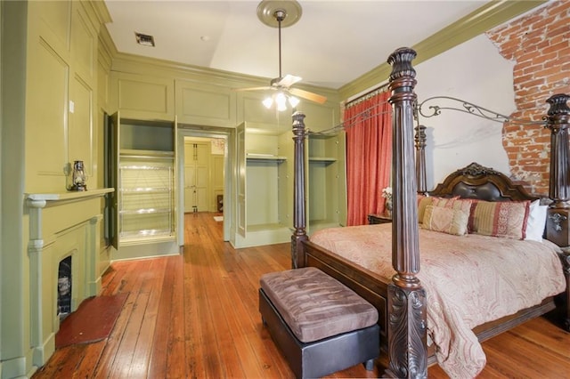 bedroom with light hardwood / wood-style floors, ceiling fan, and ornamental molding