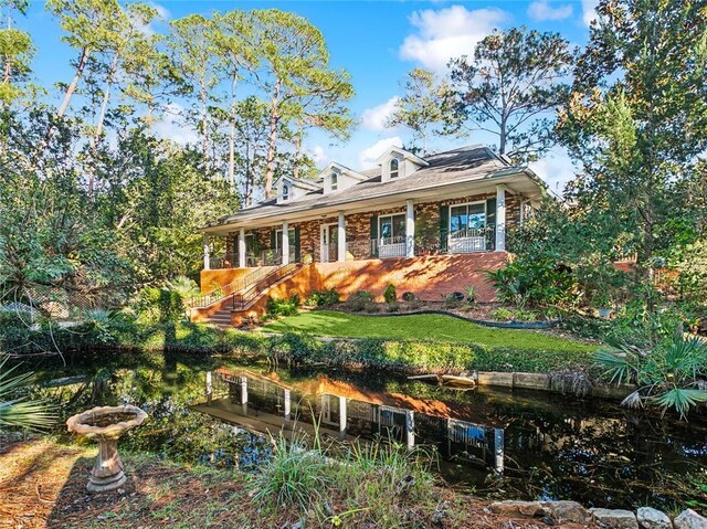 cape cod home with a front yard