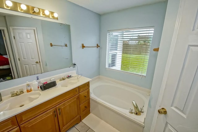 bathroom with tile patterned floors, a bathtub, and vanity