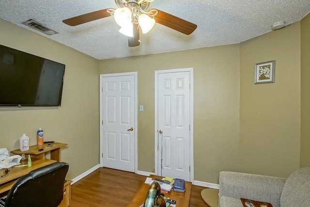 office featuring ceiling fan, wood-type flooring, and a textured ceiling