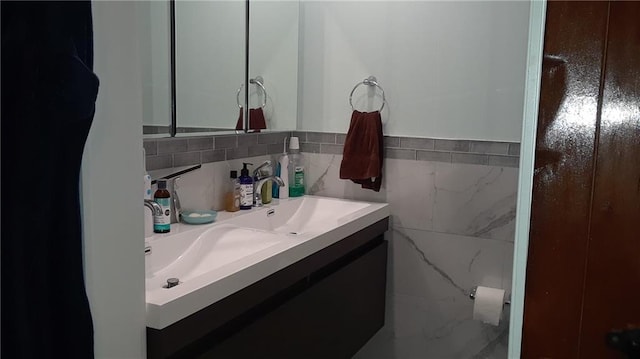 bathroom featuring vanity and tile walls