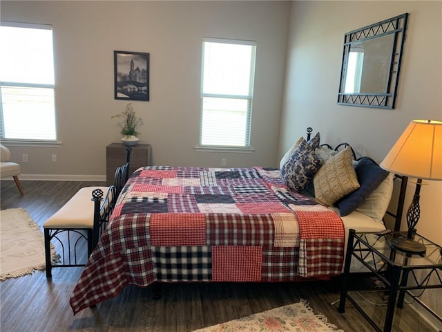 bedroom with multiple windows and dark hardwood / wood-style flooring