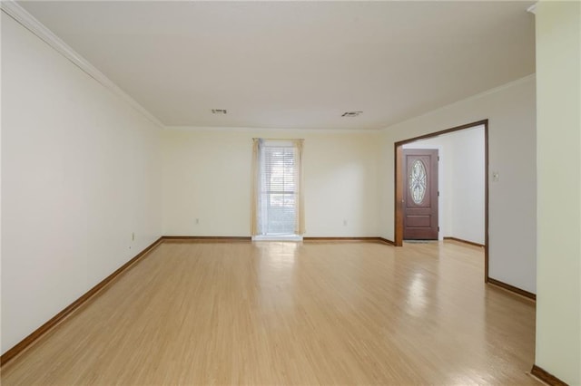 spare room featuring ornamental molding and light wood-type flooring