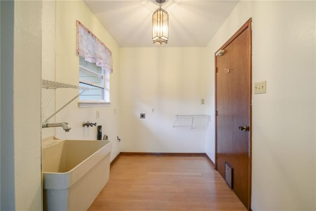 washroom with electric dryer hookup, sink, and light hardwood / wood-style flooring