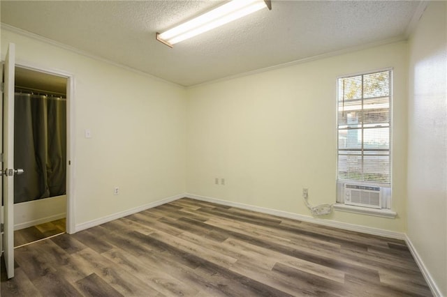 unfurnished room with a textured ceiling, dark hardwood / wood-style floors, and cooling unit