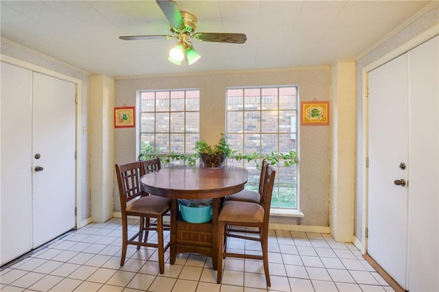 dining area with ceiling fan, light tile patterned flooring, and crown molding