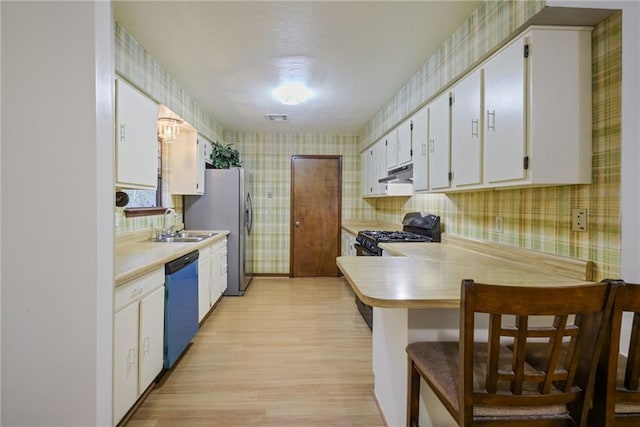 kitchen with a breakfast bar, white cabinets, light hardwood / wood-style flooring, appliances with stainless steel finishes, and kitchen peninsula