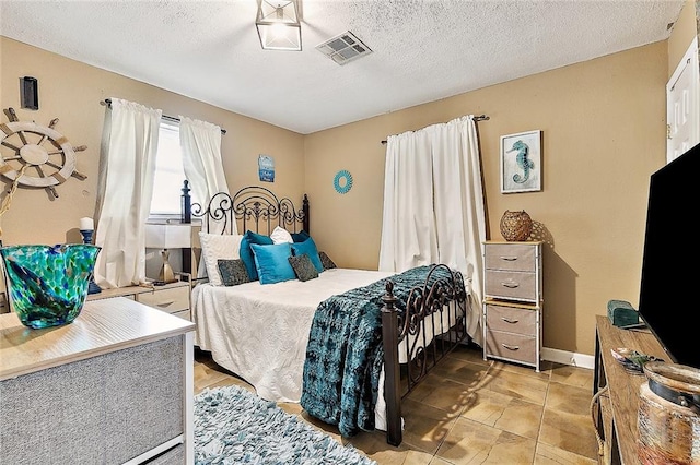 bedroom with a textured ceiling and light tile patterned flooring