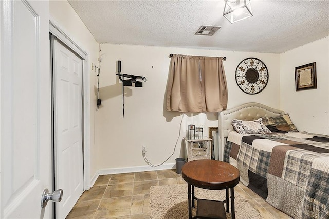 bedroom featuring a textured ceiling and a closet