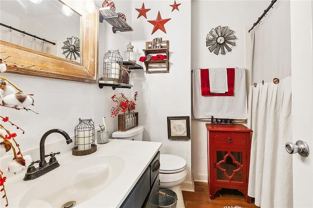 bathroom with vanity, hardwood / wood-style flooring, and toilet