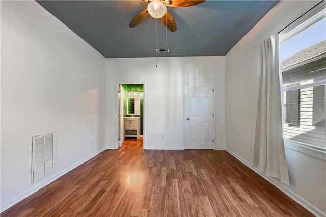 unfurnished bedroom featuring ceiling fan, hardwood / wood-style floors, and ensuite bathroom