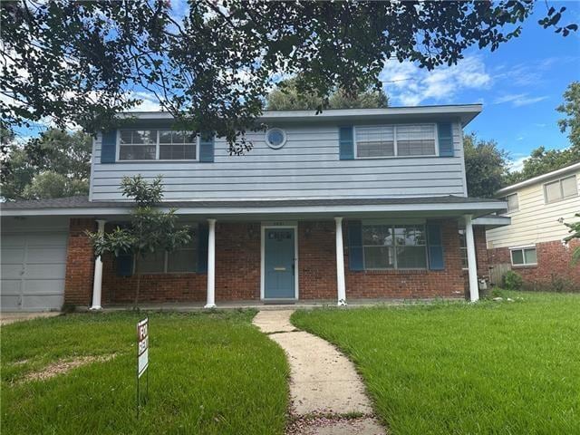 front of property with a front yard and a garage