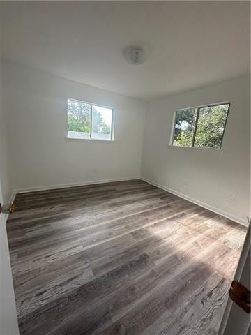 unfurnished room with dark wood-type flooring and a wealth of natural light