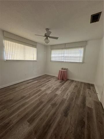 empty room with dark hardwood / wood-style floors and a wealth of natural light