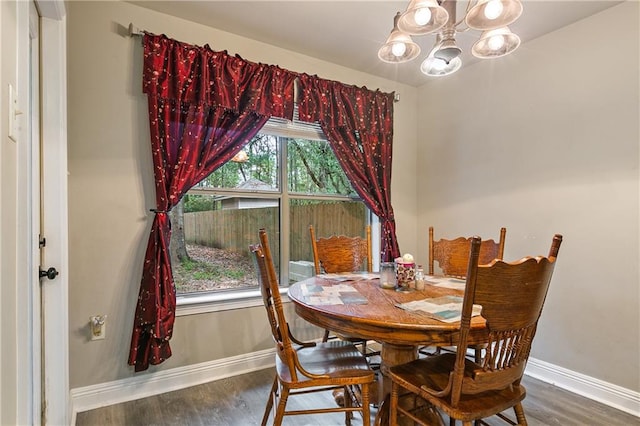 dining room featuring dark hardwood / wood-style floors and an inviting chandelier