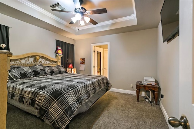 bedroom featuring ceiling fan, dark carpet, crown molding, and a tray ceiling