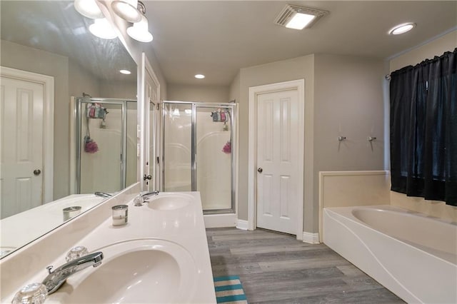 bathroom with hardwood / wood-style floors, vanity, and shower with separate bathtub