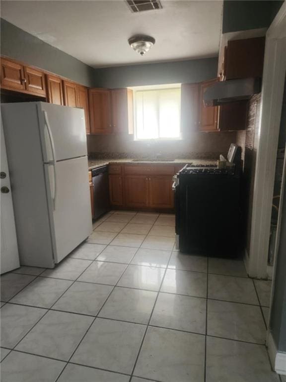 kitchen featuring light tile patterned flooring, sink, tasteful backsplash, and black appliances