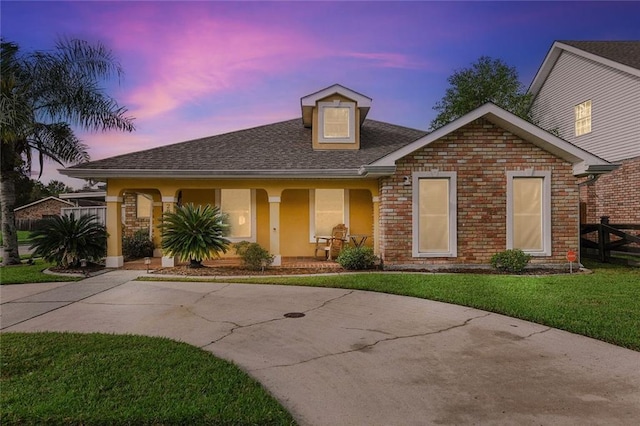 view of front of property with a porch and a lawn