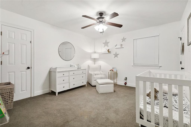 bedroom featuring ceiling fan, a crib, and light carpet