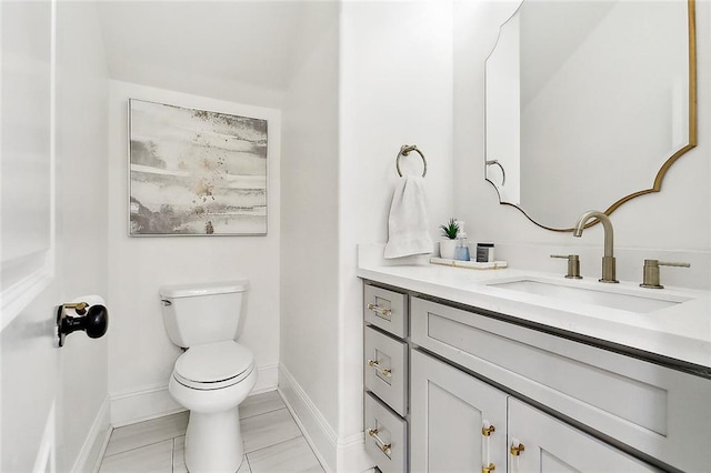 bathroom with tile patterned flooring, vanity, and toilet