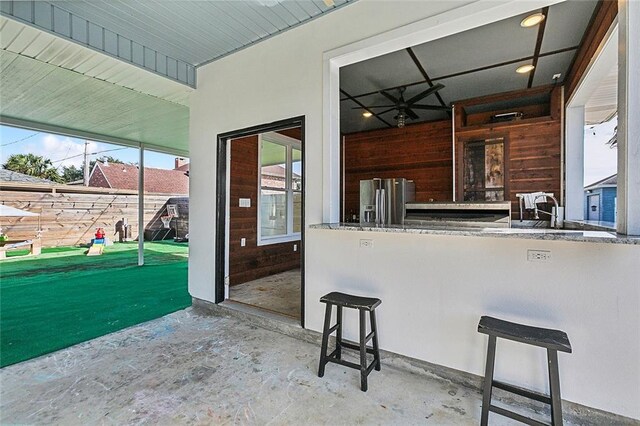 kitchen featuring wooden walls and stainless steel refrigerator with ice dispenser