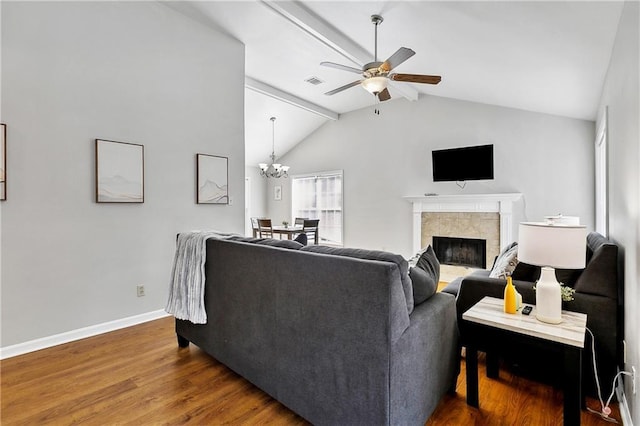 living room with hardwood / wood-style flooring, ceiling fan with notable chandelier, and lofted ceiling with beams