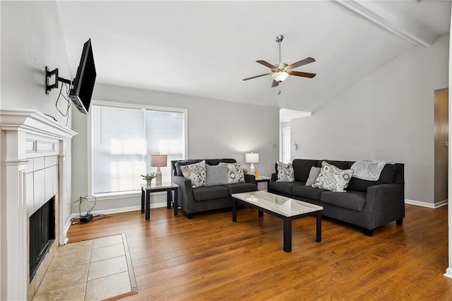 living room with ceiling fan, wood-type flooring, and vaulted ceiling with beams