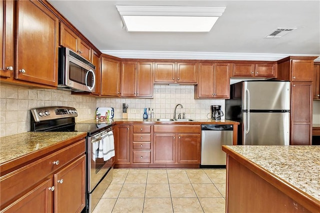 kitchen with tasteful backsplash, light tile patterned flooring, appliances with stainless steel finishes, and sink