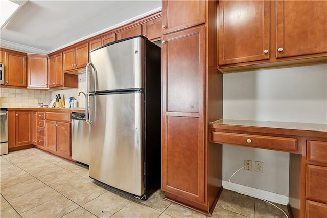 kitchen featuring tasteful backsplash, built in desk, stainless steel appliances, and light tile patterned flooring