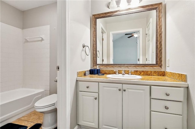 full bathroom with tile patterned floors, toilet, tiled shower / bath, vanity, and ceiling fan