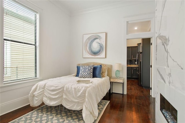 bedroom with stainless steel refrigerator, crown molding, and dark hardwood / wood-style flooring