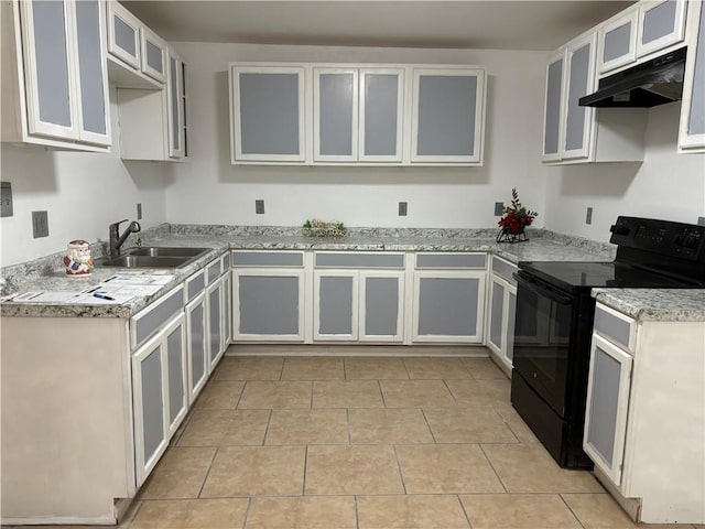 kitchen with black electric range, white cabinets, light tile patterned floors, and sink