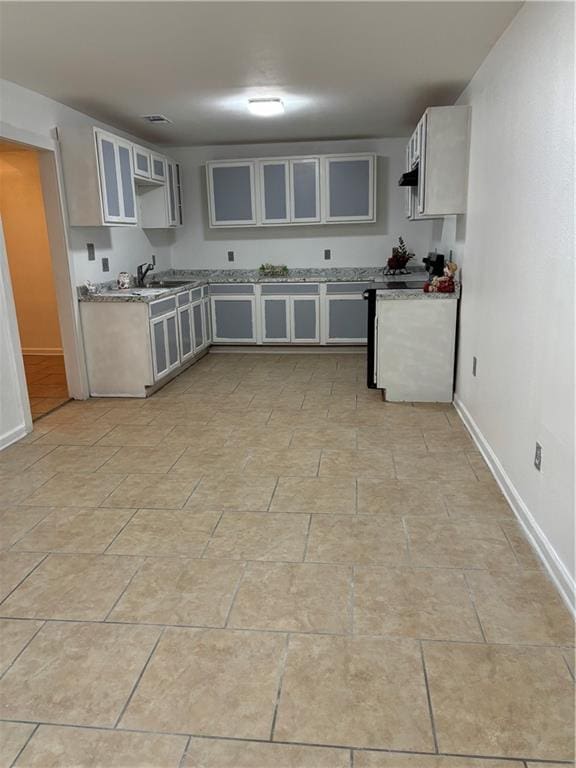 kitchen with ventilation hood, white cabinets, and sink