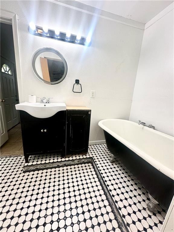 bathroom with a tub, tile patterned flooring, and vanity