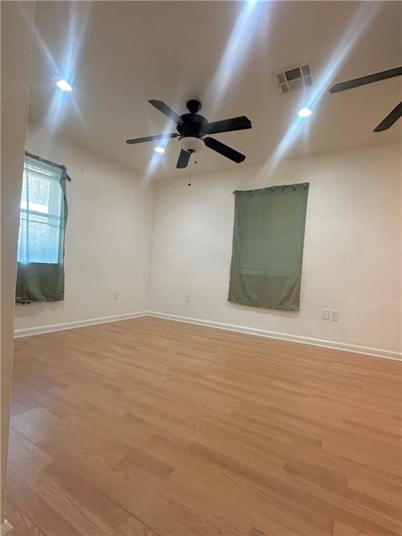 empty room featuring light wood-type flooring and ceiling fan